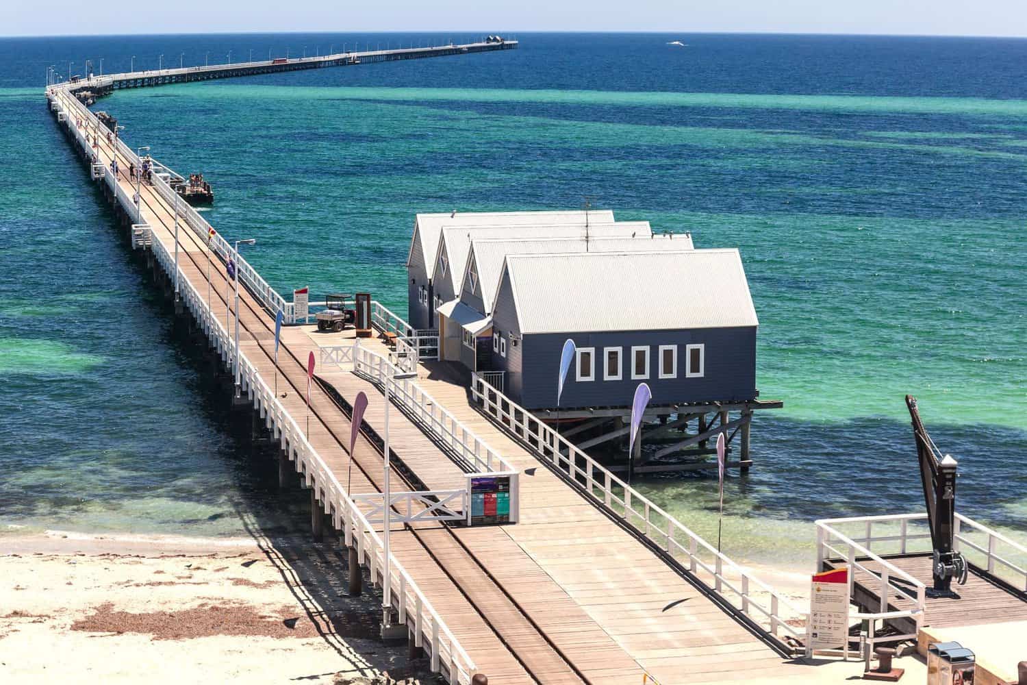 The Busselton Jetty extends into the turquoise waters of Margaret River, with the Underwater Observatory visible, a landmark destination for visitors and a picturesque spot for fishing activities.