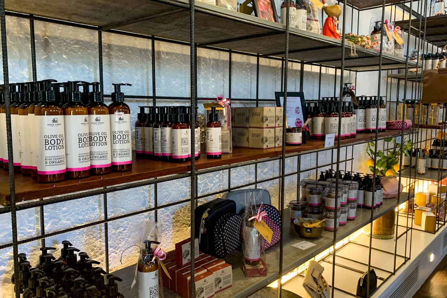 Shelves stocked with olive oil body lotions and local skincare products at a boutique shop, showcasing the artisanal and locally-made items available for tourists exploring shopping options in Margaret River.