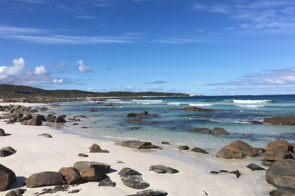 Rocky shoreline and crystal-clear waters of Margaret River's coast, a natural treasure trove of biodiversity and surf culture.