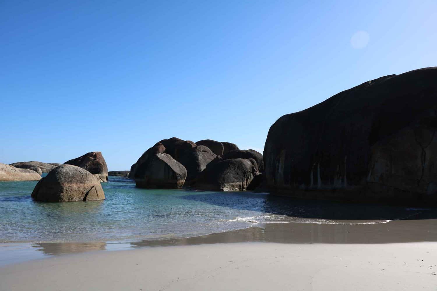 Crystal clear water lapping at the shore of a beach at a free camp near Albany