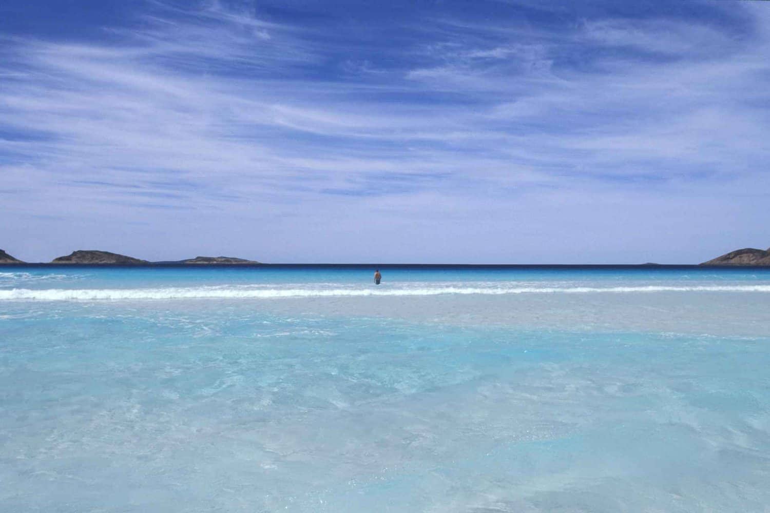 Beautiful blue sky with the sun shining down on the crystal clear water at a free camping spot near Esperance