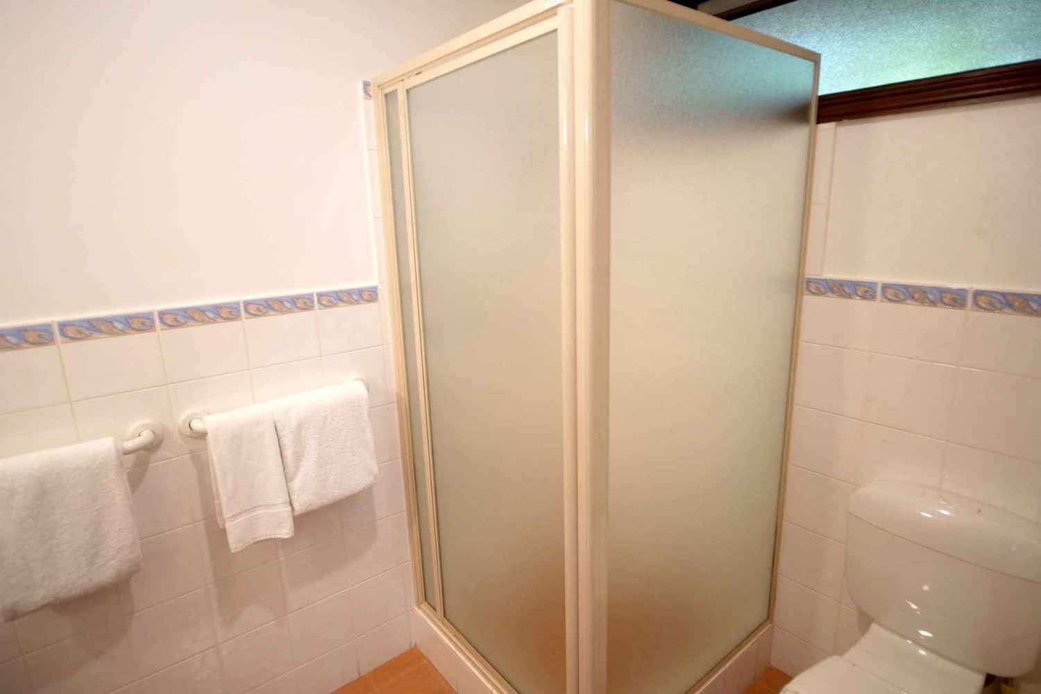 A simple 2.5-star hotel bathroom with basic fixtures, clean towels, and essential toiletries for a no-frills, budget-friendly experience.