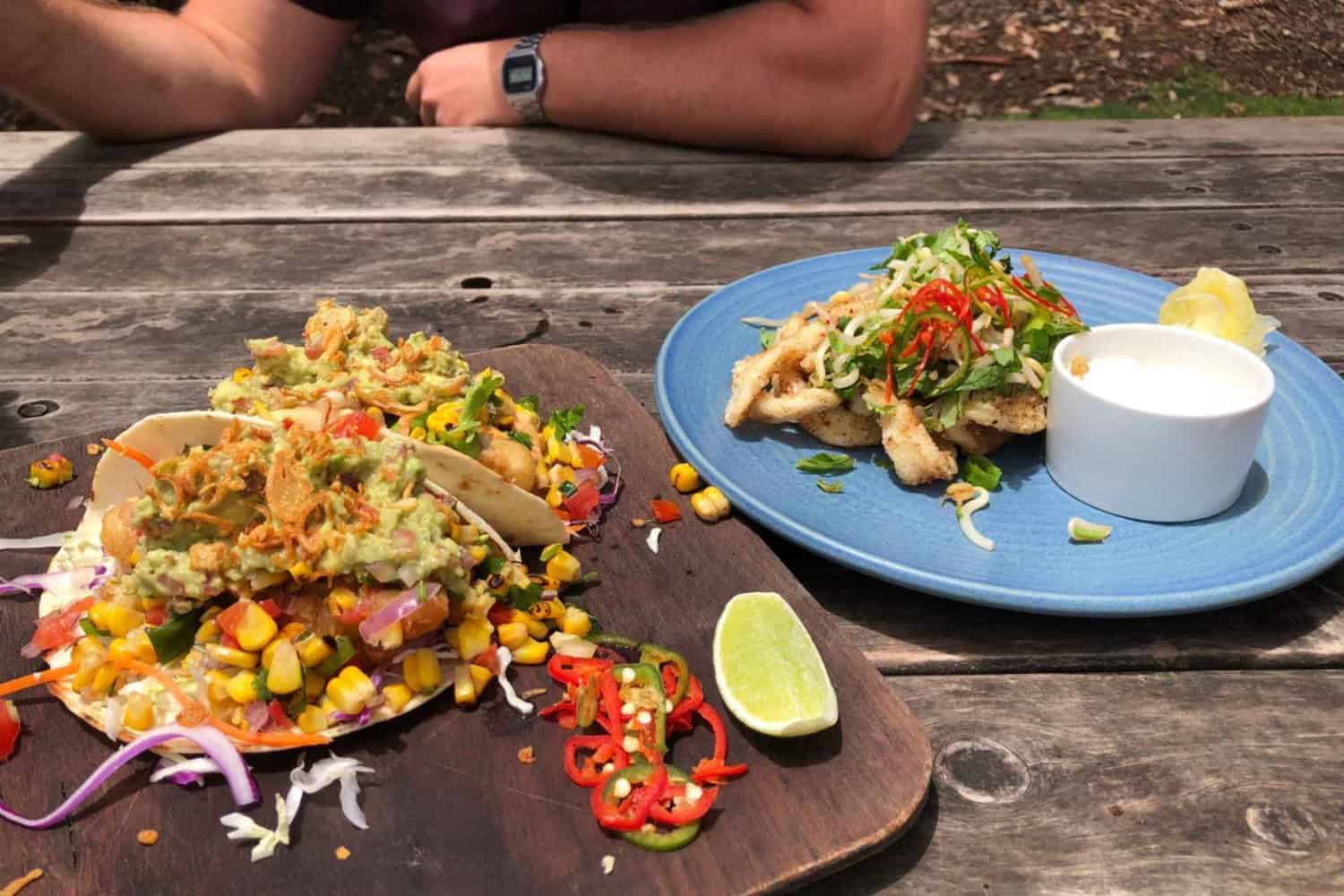 Image of two plates of food ordered at a local Margaret River restaurant, one being tacos and the other being a chicken dish, illustrating the difference between hotel and restaurant cuisine in Margaret River.