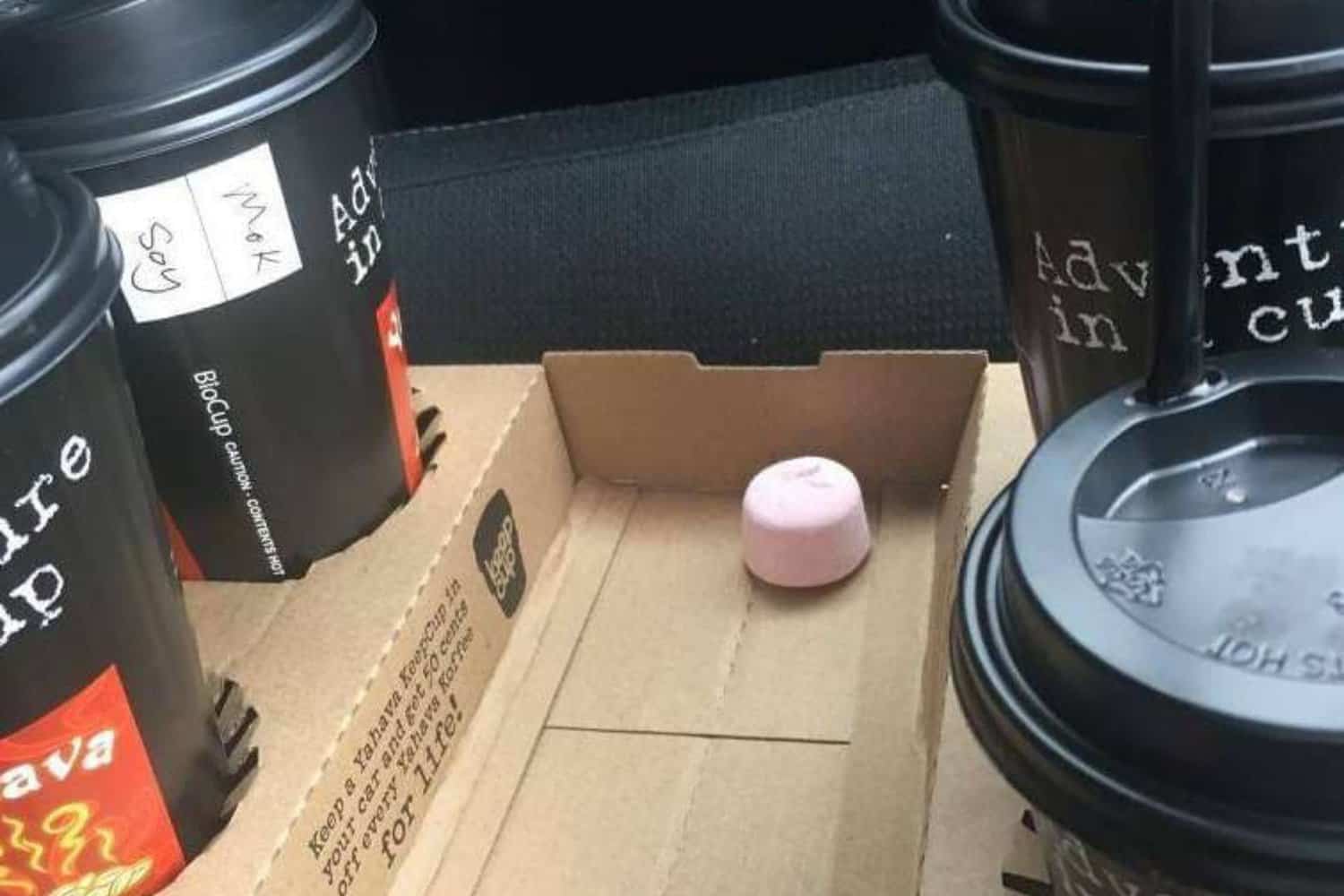 A carry tray holding four takeaway cups of the best coffee in Margaret River, each served with a delightful marshmallow to enhance the coffee experience.