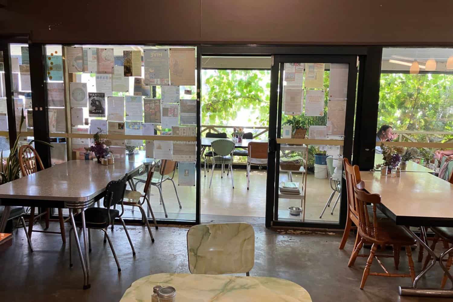 A vibrant and inviting cafe in Margaret River serving the best coffee in town. The image shows the eclectic interior with unique tables and chairs, a skilled barista behind the counter, and customers happily enjoying their freshly brewed cups of coffee.