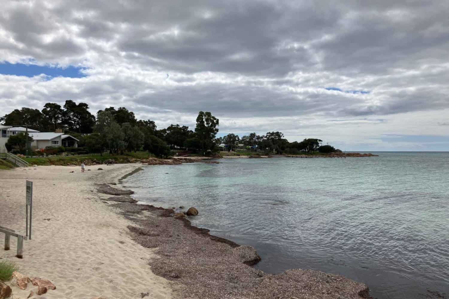 Cloudy sky over the peaceful Old Dunsborough Beach with beachfront houses nestled among trees.